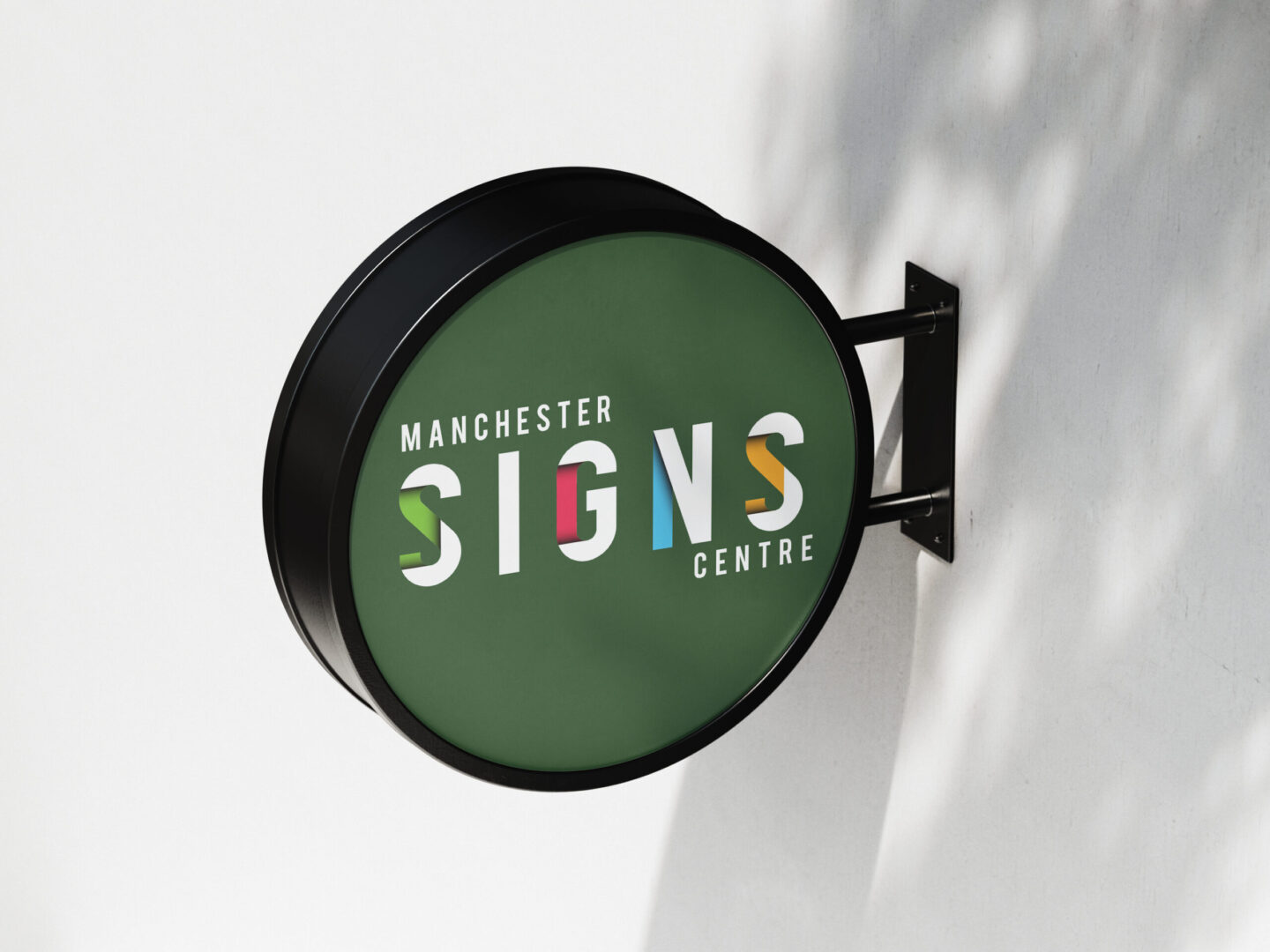 Sign on a wall displaying "Manchester Signs Centre" in bold letters against a textured background.