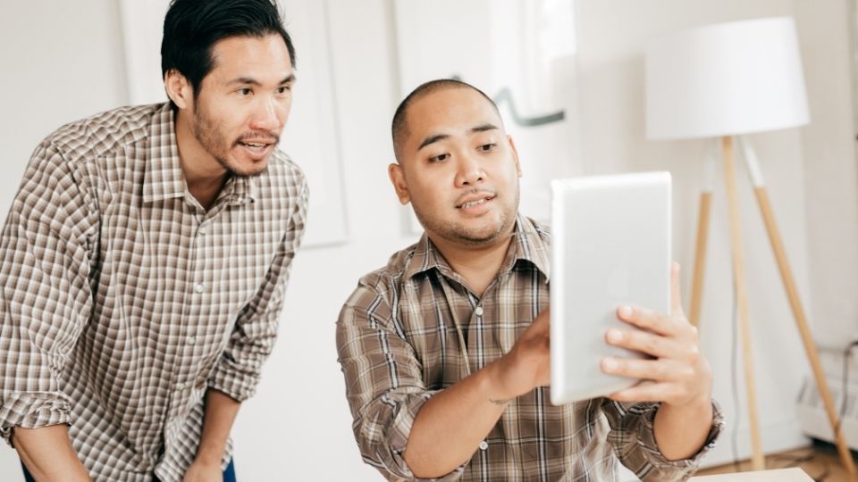 (An Image can be seen showing two designer looking at interior designs for inspiration) How to Get Inspired Interior Design with Signage