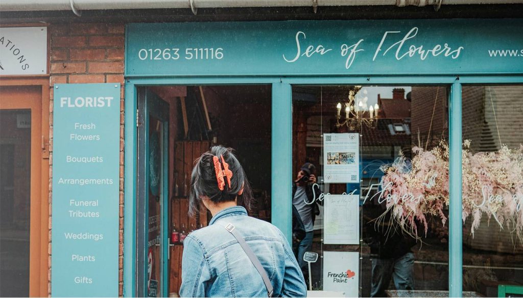 
This image is showing a customer being attracted to a shop from it’s outdoor sign, referring to the Benefits of Using Interactive Outdoor Signs